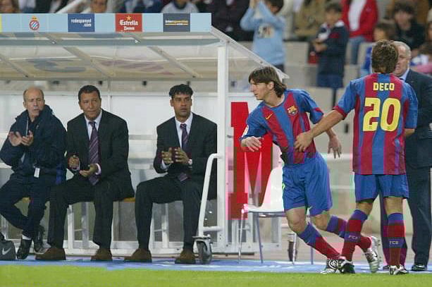 এই সেই ঐতিহাসিক মুহূর্ত, ডেকোর বদলি হিসেবে মাঠে নামছেন মেসি।বার্সেলোনার হয়ে তাঁর লা লিগা অভিষেক, ২০০৪ সালের অক্টোবরে।মেসির মাঠে নামা দেখছেন তখনকার কোচ রাইকার্ড (বেঞ্চে বসা) —ফাইল ছবি