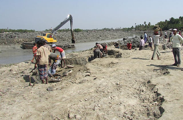 সাতক্ষীরার তালা ও খুলনার পাইকগাছা উপজেলার সীমানায় কপিলমুনি বাজারের পশ্চিম পাশে কপোতাক্ষ নদের বুকে ভরাট স্থানে মাছের আড়ত নির্মাণের কাজ চলছে। ৮ মার্চ তোলা ছবি । প্রথম আলো