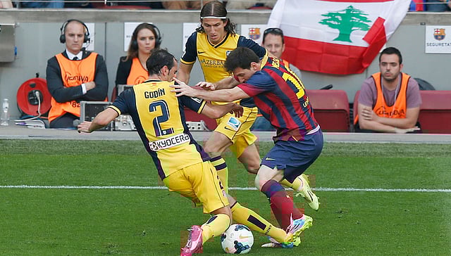 লা লিগার শিরোপা নির্ধারণী ম্যাচে লিওনেল মেসির কাছ থেকে বল কেড়ে নিচ্ছেন অ্যাটলেটিকোর গোডিন। মেসির ক্ষেত্রে এমন দৃশ্য এ মৌসুমে অনেকবারই দেখা গেছে। ছবি: রয়টার্স