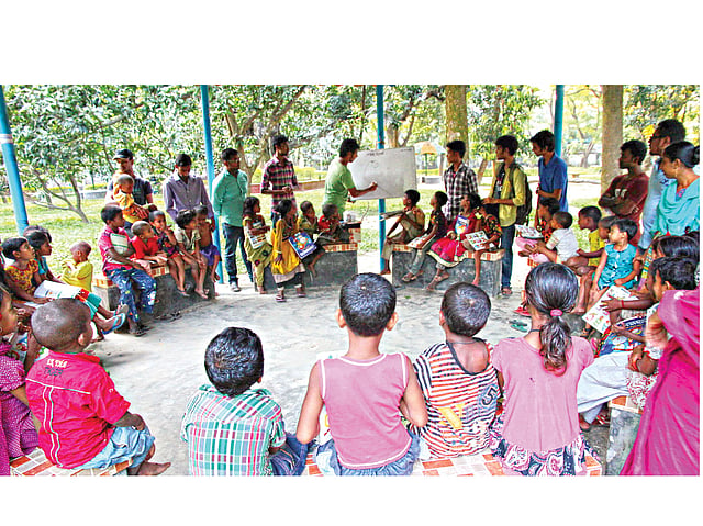বগুড়া শহরের এডওয়ার্ড পার্কে পথশিশুদের পাঠদান করাচ্ছেন আহসান হাবিব ও তাঁর বন্ধুরা। সম্প্রতি তোলা ছবি l প্রথম আলো