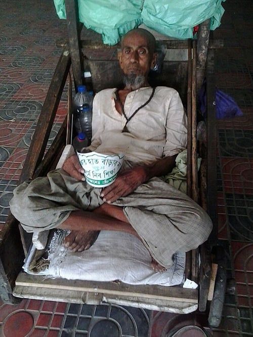 ভিক্ষুক মোতাহার সমাবেশের পুরো সময় সিঁড়ির কাছে বসে কাটান। ছবি: মানসুরা হোসাইন