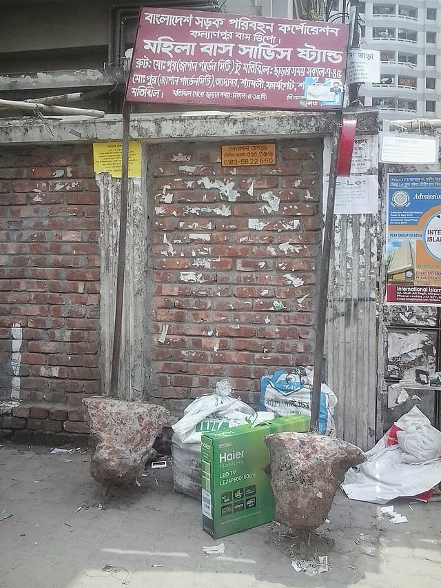 মহিলা বাস সার্ভিসের সাইনবোর্ড টাঙানো, তবে বাসের দেখা মেলে না। মোহাম্মদপুরের জাপান গার্ডেন সিটির কাছ থেকে তোলা ছবি। ছবি: মানসুরা হোসাইন