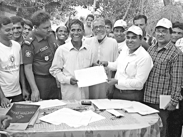 সদ্য বিলুপ্ত ১৩২ নম্বর বাঁশকাটা ছিটমহরি বাসিন্দাদের হাতে গতকাল ভূমি মালিকানার খতিয়ান হস্তান্তর করেন উপজেলা সহকারী কমিশনার (ভূমি) টি এম এ মোমিন l ছবি: প্রথম আলো
