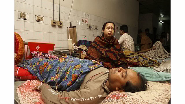 হাসপাতালের বেডে শুয়ে আছেন ‘পুলিশের নির্যাতনের শিকার’ ঢাকা দক্ষিণ সিটি করপোরেশনের পরিচ্ছন্নতাকর্মীদের পরিদর্শক বিকাশ চন্দ্র দাস। পাশে বিমর্ষ হয়ে বসে আছেন স্ত্রী সরস্বতী রানী দাস। ছবিটি শুক্রবার বেলা তিনটার দিকে ঢাকা মেডিকেল কলেজ হাসপাতাল থেকে তোলা। ছবি: আবদুস সালাম