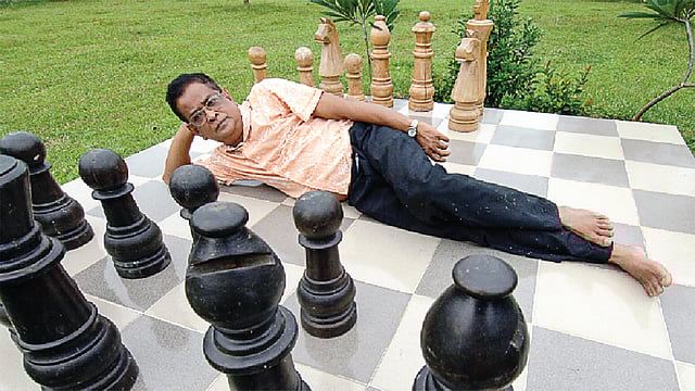 নুহাশপল্লীতে বিশাল দাবা ছকের মাঝখানে হুমায়ূন আহমেদ। ছবি: নাসির আলী মামুন/ফটোজিয়াম