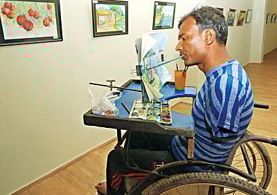 দুই হাত নেই। পা দুটিও অচল। তবু থেমে নেই তাঁর ছবি আঁকা। মুখে তুলি নিয়ে এঁকে চলেছেন এমদাদুল মল্লিক। বনানীর গ্যালারি লীলাতে চলছে তঁার চিত্র প্রদর্শনী। ছবিটি গতকাল তোলা l প্রথম আলো