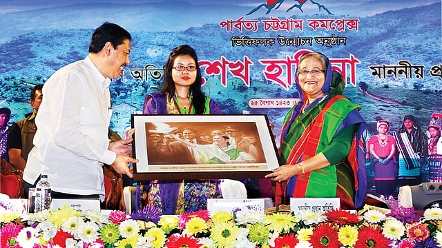 রাজধানীর বেইলি রোডে গতকাল পার্বত্য চট্টগ্রাম কমপ্লেক্সের ভিত্তিফলক উন্মোচন অনুষ্ঠানে প্রধানমন্ত্রী শেখ হাসিনার হাতে উপহার হিসেবে একটি ছবি তুলে দেন পার্বত্য চট্টগ্রাম-বিষয়ক মন্ত্রণালয়ের প্রতিমন্ত্রী বীর বাহাদুর উ শৈ সিং l ছবি: বাসস