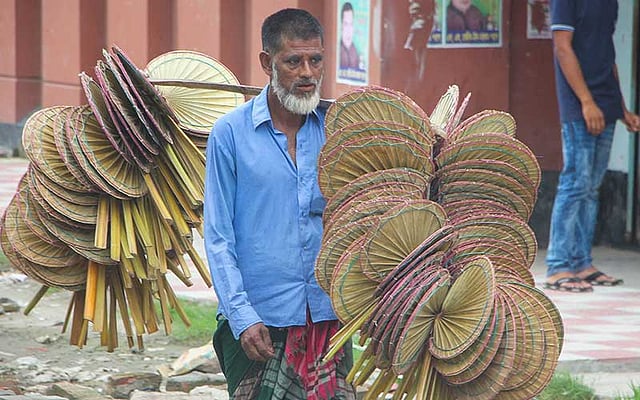 তালপাতার হাতপাখা বানিয়ে ফেরি করা হচ্ছে। ছবিটি আজ বৃহস্পতিবার খুলনার বয়রা এলাকা থেকে তোলা। ছবি: মো. সাদ্দাম হোসেন