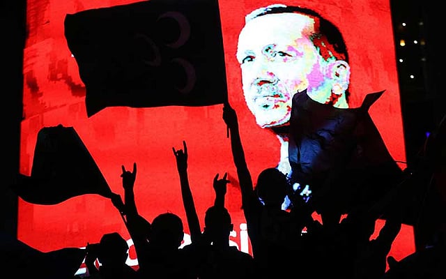 সেনা অভ্যুত্থান ব্যর্থ করে দেওয়ার পর তুরস্কের প্রেসিডেন্ট রিসেপ তাইয়েপ এরদোয়ানের ছবির সামনে সমর্থকদের উল্লাস। ছবি: এএফপি