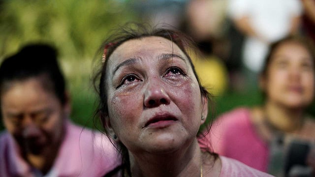 রাজা ভূমিবলের মৃত্যুর খবরে কাঁদছেন এক নারী। ছবিটি গতকাল বৃহস্পতিবারের। ছবি: রয়টার্স