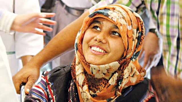 খাদিজা বেগম হাসছেন। গতকাল রাজধানীর স্কয়ার হাসপাতালের নিচতলায় সাংবাদিকদের সামনে আনা হয় তাঁকে l ছবি: প্রথম আলো