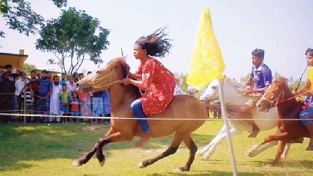 প্রতিদ্বন্দ্বীকে পেছনে ফেলে দুরন্ত বেগে ঘোড়া ছোটাচ্ছে তাসমিনা আক্তার। দৃশ্যটি ঘোড়সওয়ার প্রামাণ্যচিত্র থেকে নেওয়া