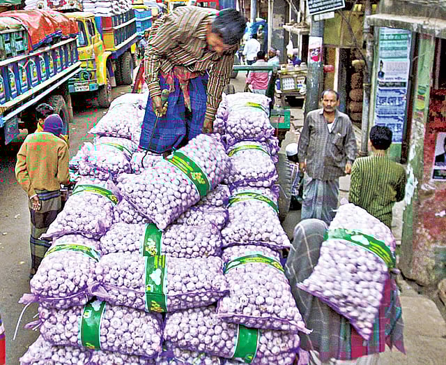 চট্টগ্রামের খাতুনগঞ্জ পাইকারি মোকামে আমদানি করা পণ্য ওঠানো-নামানোর কাজে ব্যস্ত শ্রমিক l প্রথম আলো