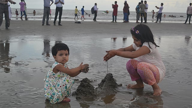 কুয়াকাটা সৈকতে বালু নিয়ে খেলছে দুই শিশু। ছবি: শংকর দাশ
