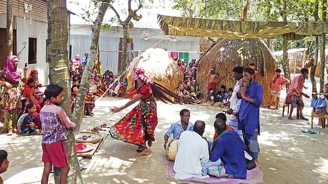 আসরে বয়াতির গান আর ঢুলির বাজনার তালে নাচছেন একজন। ছবি: লেখক