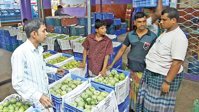 পুরান ঢাকার বাদামতলী ফলের আড়তে আমের দরদাম করছেন ক্রেতারা। ছবিটি গতকাল তোলা l প্রথম আলো