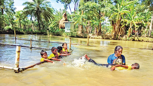 শিশুদের সাঁতার শেখাচ্ছেন একজন প্রশিক্ষক। ছবি: ছুটির দিনে