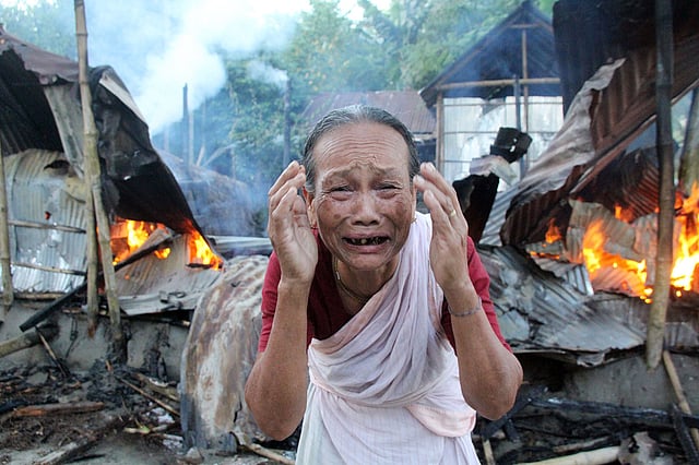 আগুনে জ্বলছে বাড়ি, সামনে বৃদ্ধার আহাজারি। ১০ নভেম্বর, হরকলি ঠাকুরপাড়া, রংপুর। ছবি: মঈনুল ইসলাম