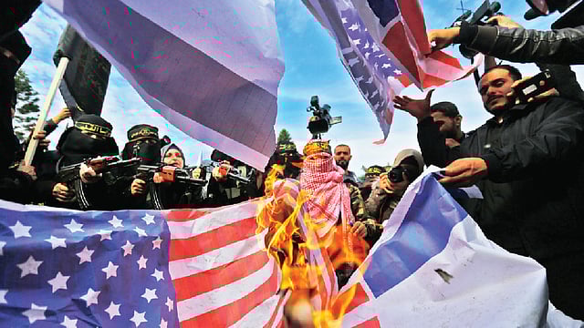 ট্রাম্পের ঘোষণার প্রতিবাদে মার্কিন পতাকা পোড়াচ্ছেন বিক্ষুব্ধ ফিলিস্তিনিরা। ছবি: এএফপি