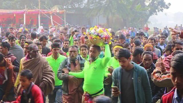 মাথায় হুমঘুঁটি নিয়ে দৌড়াচ্ছেন একজন। গতকাল ময়মনসিংহের ফুলবাড়িয়া উপজেলার আটা গ্রামে l প্রথম আলো