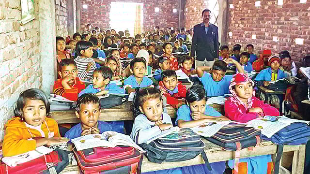 শ্রেণিকক্ষ ও বেঞ্চসংকট থাকায় শিক্ষার্থীরা বসে গাদাগাদি করে। গত রোববার খুলনার মুহাম্মদনগর সরকারি প্রাথমিক বিদ্যালয়ে l ছবি: প্রথম আলো