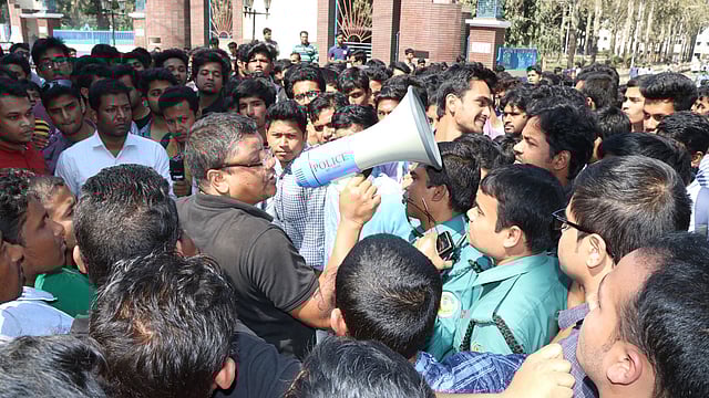আন্দোলনরত শিক্ষার্থীদের শান্ত করার চেষ্টা করছেন শিক্ষক এনামুল জহির। রাজশাহী বিশ্ববিদ্যালয়, ১৫ ফেব্রুয়ারি। ছবি: প্রথম আলো