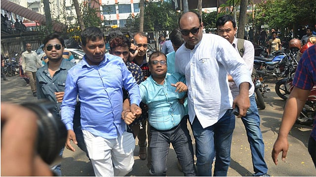 স্বেচ্ছাসেবক দলের সভাপতিকে ধরে নিয়ে যাচ্ছেন তাঁরা। ছবি: সাজিদ হোসেন