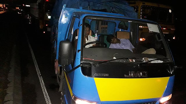 ঢাকা-চট্টগ্রাম মহাসড়কে দাউদকান্দিতে প্রায় ৪০ কিলোমিটার যানজট সৃষ্টি হয়েছে। শুক্রবার রাত সাড়ে আটটার দিকে মহাসড়কের দাউদকান্দির গৌরীপুরে থেমে থাকা একটি ট্রাকে চালকের সহকারীকে ঘুমিয়ে থাকতে দেখা যায়। ছবি: আবদুর রহমান