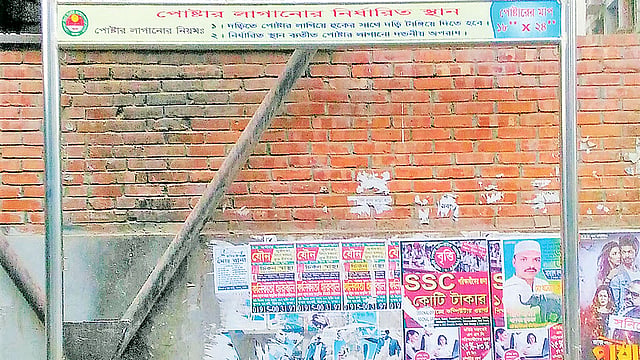 পোস্টার লাগানোর নির্ধারিত স্থান ফাঁকা। অথচ পোস্টার লাগানো হয়েছে পেছনের দেয়ালে। গত সোমবার মিরপুর–২ নম্বরে পিডব্লিউডি স্টাফ কোয়ার্টারের সামনে। প্রথম আলো