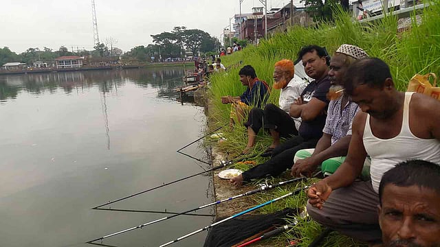 মাদারীপুরে শকুনি লেকে শুক্রবার সকাল থেকে ছিপ দিয়ে মাছ শিকারের প্রতিযোগিতা শুরু হয়েছে। চলবে শনিবার সন্ধ্যা পর্যন্ত। ছবি: অজয় কুন্ডু