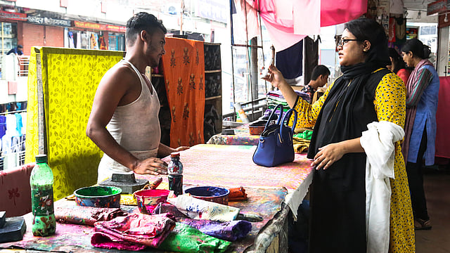 পোশাকে কোন নকশা হবে, তা বুঝিয়ে দিচ্ছেন কারিগরকে।