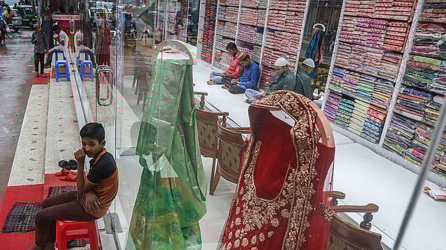 সড়ক কেটে রাখায় বেচাবিক্রি কমে গেছে মিরপুরের বেনারসিপল্লিতে। অলস সময় কাটছে দোকান মালিক ও কর্মচারীদের। গত মঙ্গলবার তোলা ছবি। প্রথম আলো