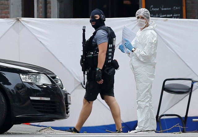 মুখোশ পড়া একজন পুলিশ সদস্য ও একজন ফরেনসিক বিশেষজ্ঞ ঘটনাস্থল থেকে আলামত সংগ্রহ করছেন। লি গে, বেলজিয়াম, ২৯ মে। ছবি: রয়টার্স