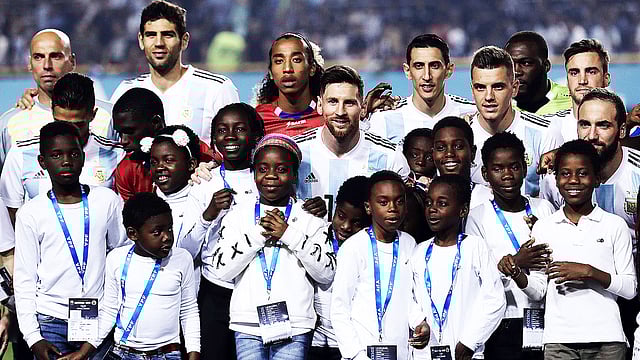 ম্যাচ শুরুর আগে শিশুদের সঙ্গে দুই দলের খেলোয়াড়েরা। ছবি: এএফপি