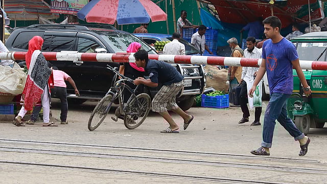 রাজধানীর আশকোনার হাজি ক্যাম্পের কাছের রেলগেট। গেট পরে যাওয়ার পরও নিচ দিয়ে পারাপার হচ্ছে পথচারীরা। ছবি: শুভ্র কান্তি দাশ