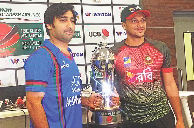 কাল দেরাদুনে ট্রফি মাঝে রেখে আসগর স্টানিকজাই (বাঁয়ে) ও সাকিব আল হাসানের মুখে সৌজন্য হাসি। যেটি বদলে যেতে সময় লাগার কথা নয়! আজ রাতেই যে শুরু হয়ে যাচ্ছে দুই দেশের মধে্য তিন ম্যাচের টি-টোয়েন্টি সিরিজ। ছবি: প্রথম আলো