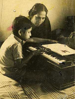 মায়ের কাছ থেকে ছোটবেলায় ‘আনন্দলোকে...’ গানটি শেখা হচ্ছে। ছবি: পারিবারিক অ্যালবাম থেকে