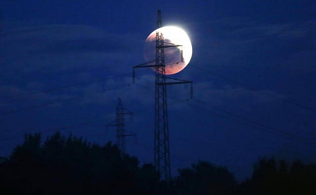 দেখে যেন মনে হচ্ছে বিদ্যুতের খুঁটির মাথায় হচ্ছে পূর্ণগ্রাস চন্দ্রগ্রহণ। জেনিকা, বসনিয়া-হার্জেগোভিনা। ছবি: রয়টার্স
