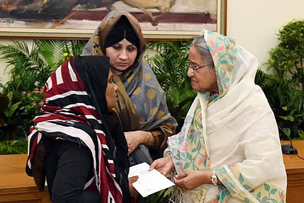 ২১ আগস্টে গ্রেনেড হামলায় হতাহত ব্যক্তিদের মধ্যে ২৫ জনের পরিবারের কাছে সঞ্চয়পত্র তুলে দেন প্রধানমন্ত্রী শেখ হাসিনা। গণভবন, ঢাকা, ৩১ জুলাই। ছবি: বাসস
