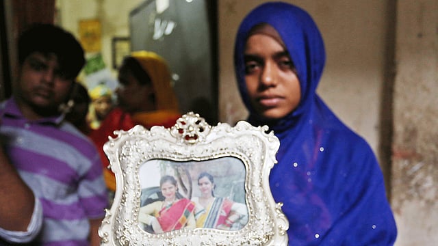 ছোট বোন দিয়াকে হারিয়ে বাকরুদ্ধ রিয়া। ফ্রেমে বন্দী দুই বোনের ছবি সান্ত্বনার বদলে শোক উসকে দিচ্ছে বেশি। ছবি: হাসান রাজা