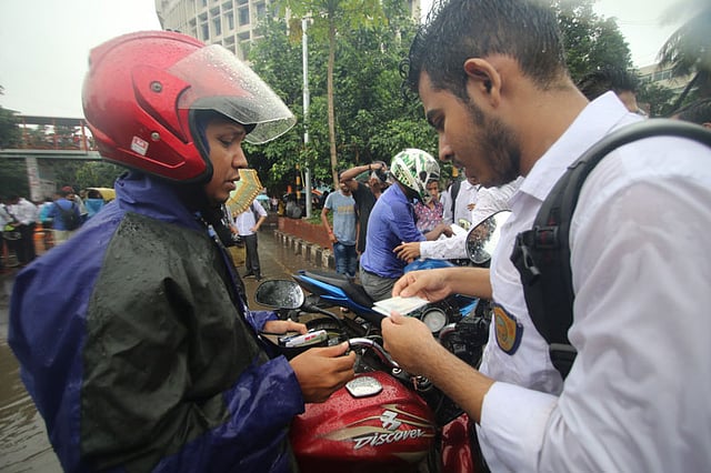 শাহবাগ মোড়ে এক মোটরসাইকেল চালকের লাইসেন্স যাচাই করছে একদল শিক্ষার্থী। ঢাকা, ২ আগস্ট। ছবি: আবদুস সালাম