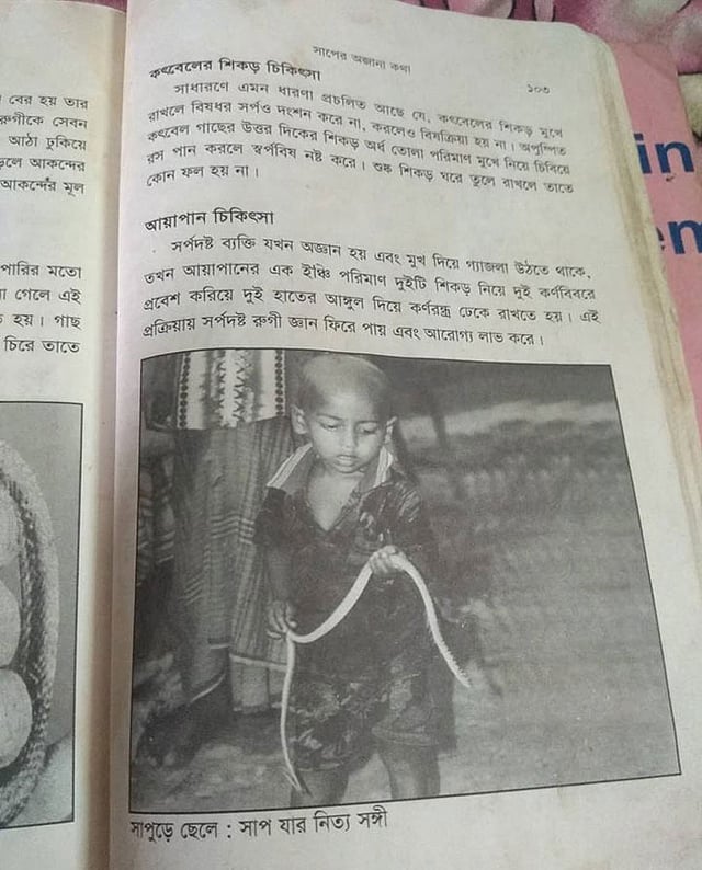 বইয়ের পাতায় সাপ হাতে মো. খোকনের ভাগনের ছবি। ছবি: প্রথম আলো