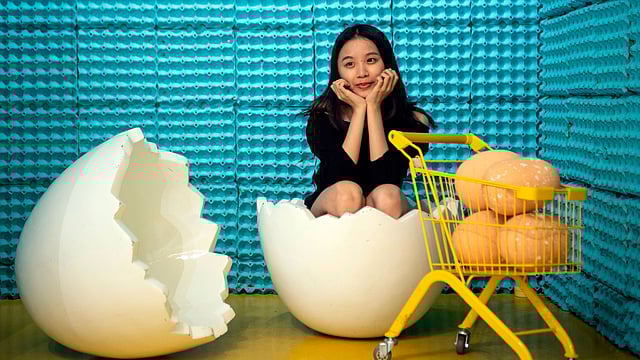 ডিমের বাড়িতে ডিমের খোসায় বসে ছবি তুলছেন এক তরুণী। গত শুক্রবার চীনের সাংহাইয়ে। এএফপি