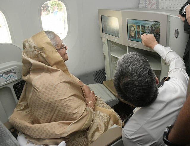 একজন পাইলট প্রধানমন্ত্রীকে যাত্রী আসনের সামনে থাকা মনিটরের ব্যবহার দেখাচ্ছেন