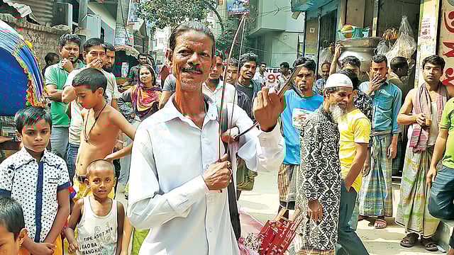 বেহালা বাজিয়ে পথচারীদের মাতিয়ে রাখেন মো. সালাউদ্দিন। ছবি: প্রথম আলো
