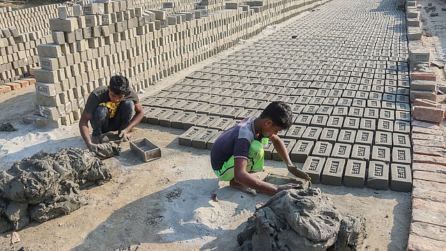 কাঠের ছাঁচে ফেলে কাঁচা ইটের আকার দেওয়া হয় মাটিকে। মোকামপুর, তেরখাদা, খুলনা, ৫ জানুয়ারি। ছবি: সাদ্দাম হোসেন