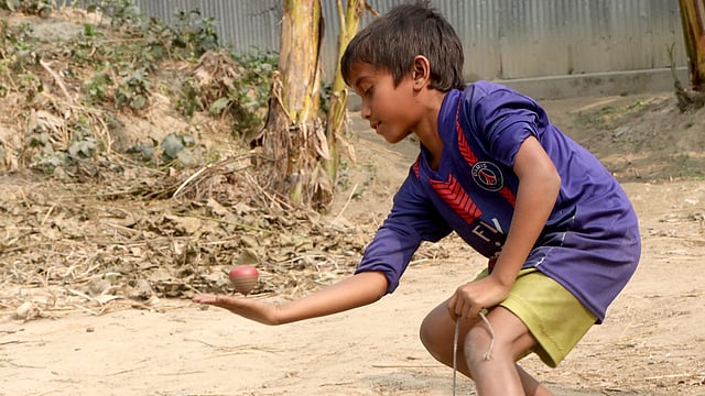 হাতে লাটিম ঘোরানো চলছে। বাগবাড়ি, গাবতলী, বগুড়া, ১৬ জানুয়ারি। ছবি: সোয়েল রানা