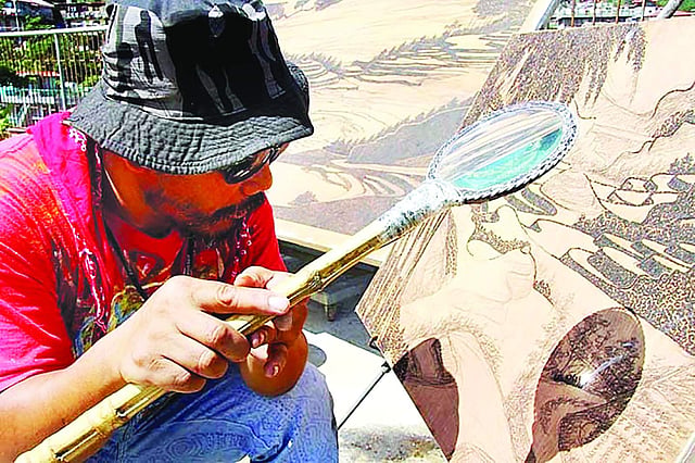 আতশি কাচ দিয়ে ছবি আঁকছেন জর্ডান মিং