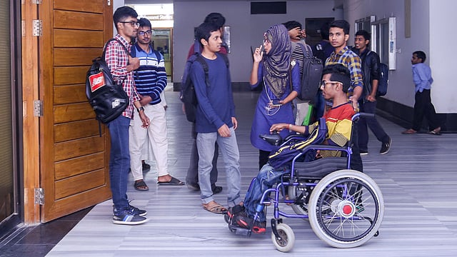 হৃদয়কে কোলে করে ক্লাসে নিতে হচ্ছে না। হৃদয় একাই হুইল চেয়ারে বিশ্ববিদ্যালয়ে যেতে পারেন। ঢাকা বিশ্ববিদ্যালয়, ২২ জানুয়ারি। ছবি: সাবরিনা ইয়াসমীন