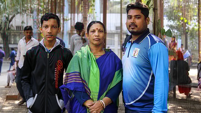 ‘খ’ ইউনিটের ভর্তি পরীক্ষার দিনে হৃদয় সরকারকে মা কোলে করে পরীক্ষার হলে নেওয়া ছবি তোলেন মনোবিজ্ঞান বিভাগের চতুর্থ বর্ষের শিক্ষার্থী এম এ আল মামুন। ফেসবুকে ওই ছবি পোস্টের পরই ব্যাপক সাড়া পড়ে। সেই আল মামুনের সঙ্গে মা ও হৃদয় সরকারের ভাই। ঢাকা বিশ্ববিদ্যালয়, ২২ জানুয়ারি। ছবি: সাবরিনা ইয়াসমীন